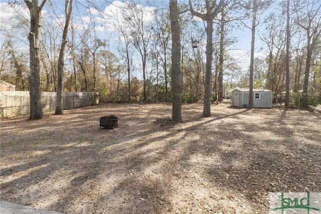 view of yard featuring a shed and a fire pit