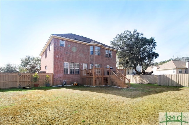 rear view of property featuring a wooden deck and a lawn