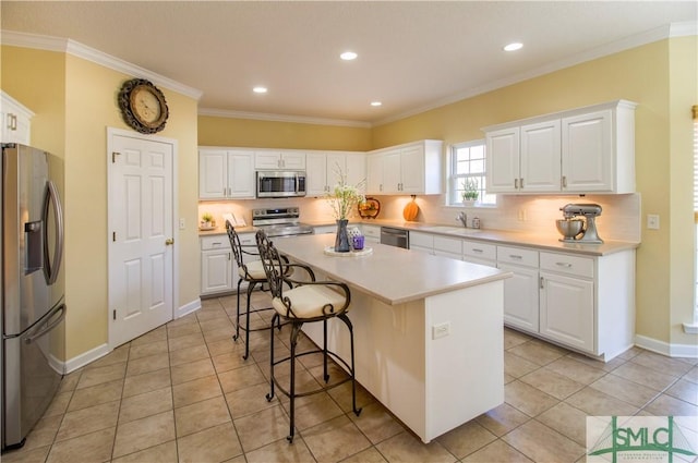 kitchen featuring sink, a breakfast bar, white cabinetry, stainless steel appliances, and a center island