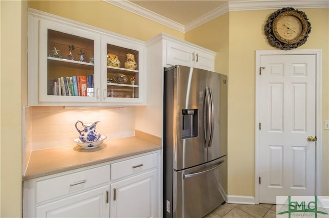 kitchen with crown molding, white cabinetry, stainless steel refrigerator with ice dispenser, tasteful backsplash, and light tile patterned flooring