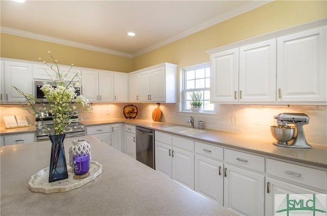 kitchen with appliances with stainless steel finishes, sink, decorative backsplash, and white cabinets