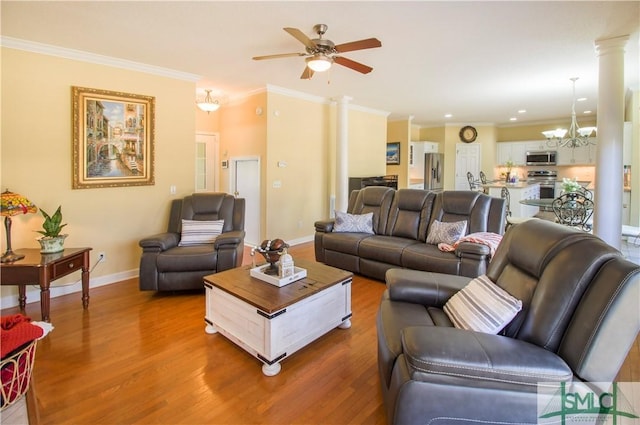 living room with ceiling fan with notable chandelier, ornamental molding, hardwood / wood-style floors, and ornate columns