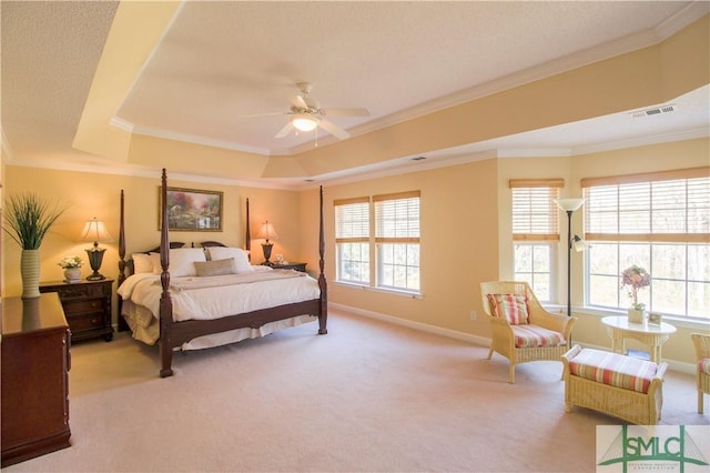 bedroom featuring ceiling fan, ornamental molding, a tray ceiling, and light carpet