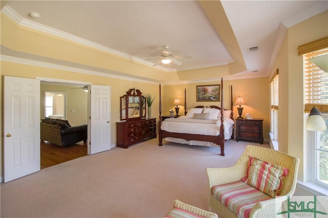 bedroom featuring carpet flooring, ornamental molding, and a tray ceiling