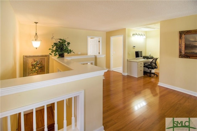 corridor featuring hardwood / wood-style floors and a textured ceiling