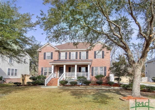 colonial-style house with covered porch and a front yard