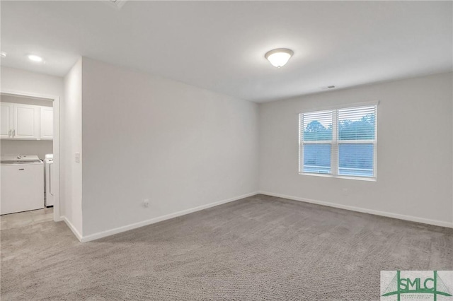 carpeted empty room featuring independent washer and dryer