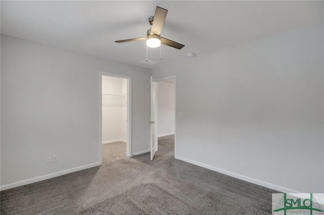 unfurnished bedroom featuring light carpet, a spacious closet, a closet, and ceiling fan