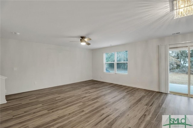 empty room featuring hardwood / wood-style floors, a wealth of natural light, and ceiling fan