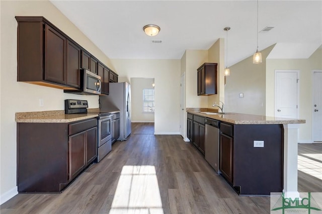 kitchen with sink, dark brown cabinets, hanging light fixtures, hardwood / wood-style flooring, and stainless steel appliances