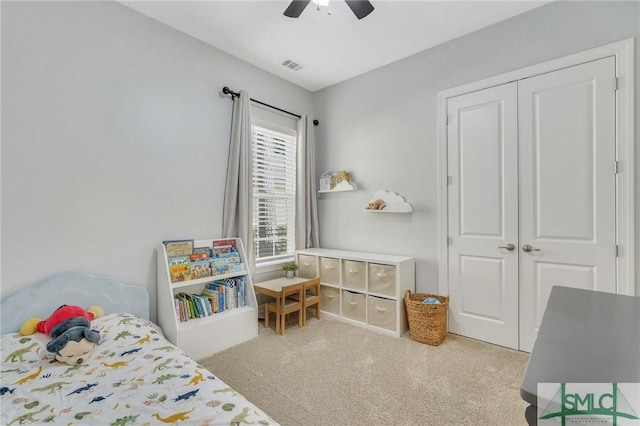 carpeted bedroom featuring ceiling fan and a closet