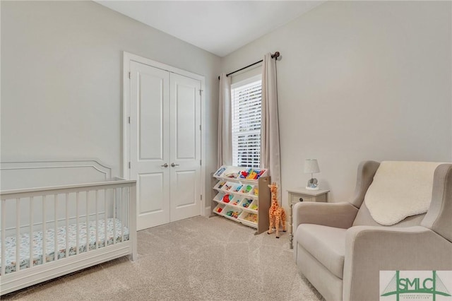 carpeted bedroom featuring a nursery area and a closet