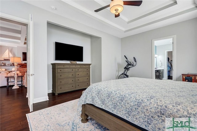 bedroom featuring a tray ceiling, dark hardwood / wood-style floors, and ceiling fan