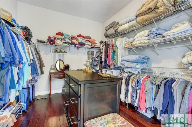 walk in closet with dark wood-type flooring