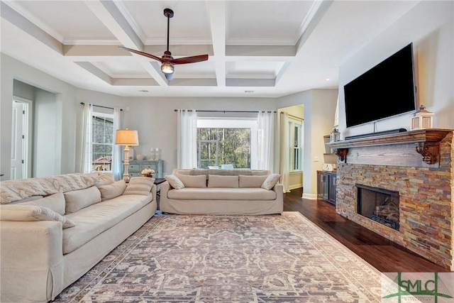 living room featuring coffered ceiling, dark hardwood / wood-style flooring, beamed ceiling, ceiling fan, and a fireplace