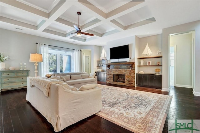 living room featuring coffered ceiling, a stone fireplace, dark hardwood / wood-style floors, and ceiling fan