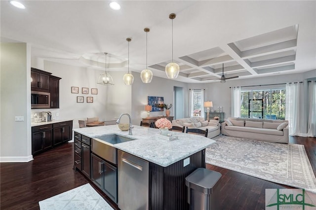 kitchen with decorative light fixtures, an island with sink, sink, dark hardwood / wood-style flooring, and stainless steel appliances