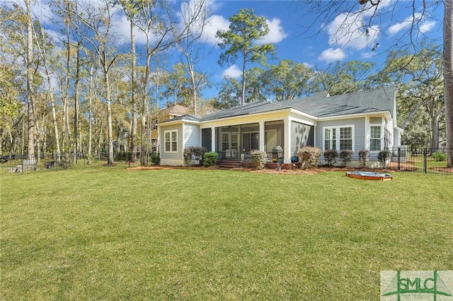 back of property featuring a sunroom and a lawn