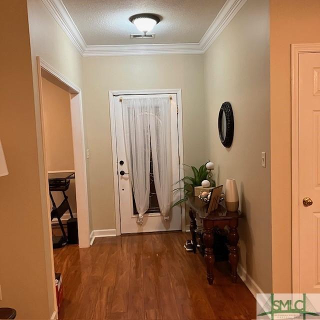 doorway to outside with dark hardwood / wood-style flooring and crown molding