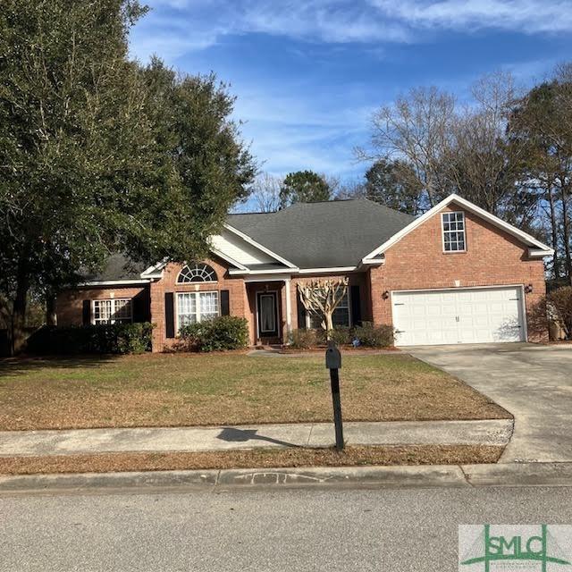 145 J Hendley Ct, Richmond Hill, GA 31324 - single story home featuring a front yard, a garage, brick siding, and driveway