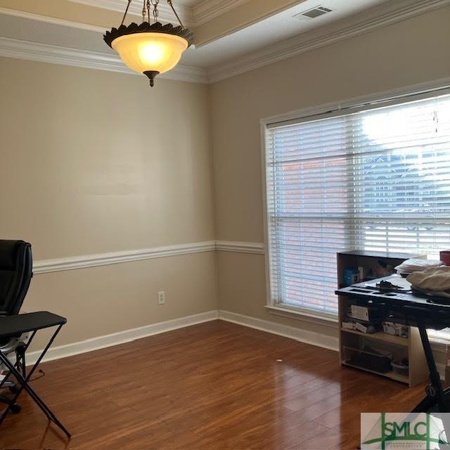 living area featuring crown molding and dark hardwood / wood-style flooring