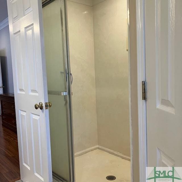 bathroom with an enclosed shower and hardwood / wood-style floors