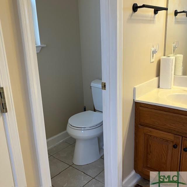 bathroom with vanity, tile patterned floors, and toilet