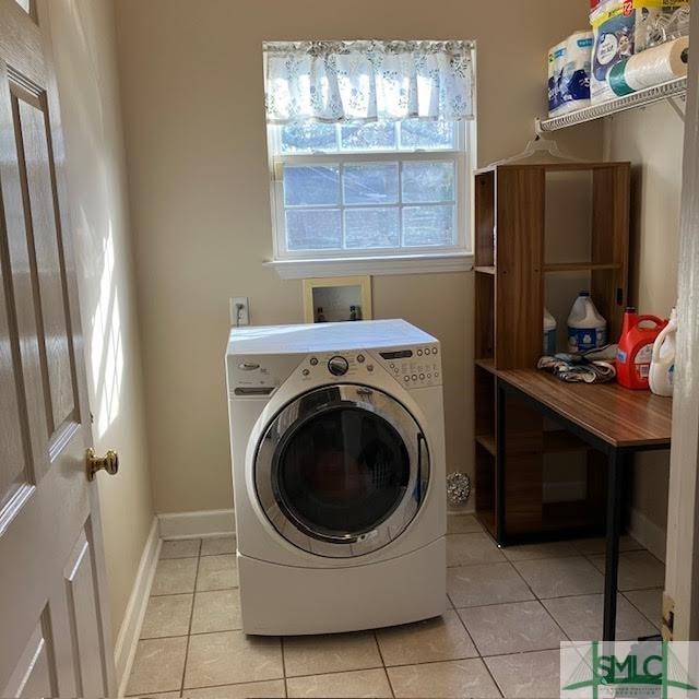 laundry area featuring light tile patterned floors and washer / dryer