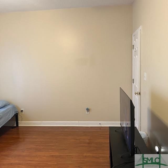 unfurnished bedroom with dark hardwood / wood-style flooring