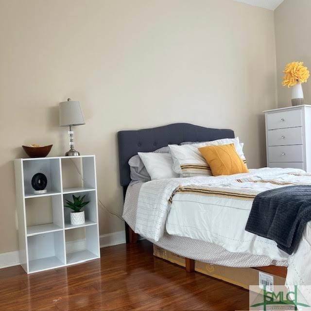 bedroom with dark hardwood / wood-style floors