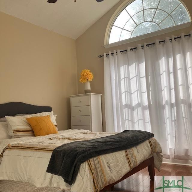 tiled bedroom featuring vaulted ceiling and ceiling fan