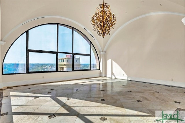 empty room featuring baseboards, a high ceiling, arched walkways, a notable chandelier, and marble finish floor