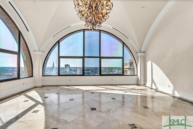 unfurnished room with a wealth of natural light, marble finish floor, and baseboards