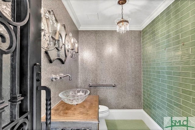 bathroom featuring vanity, toilet, crown molding, a notable chandelier, and tile patterned floors