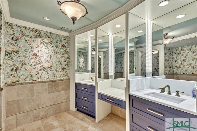 bathroom with wallpapered walls, visible vents, vanity, and a wainscoted wall