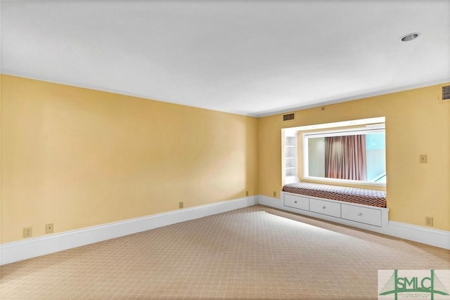 spare room featuring visible vents, carpet flooring, and baseboards