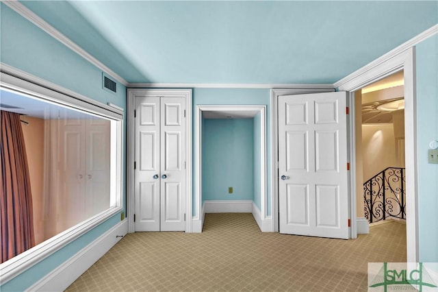 unfurnished bedroom featuring light carpet, visible vents, a closet, and baseboards