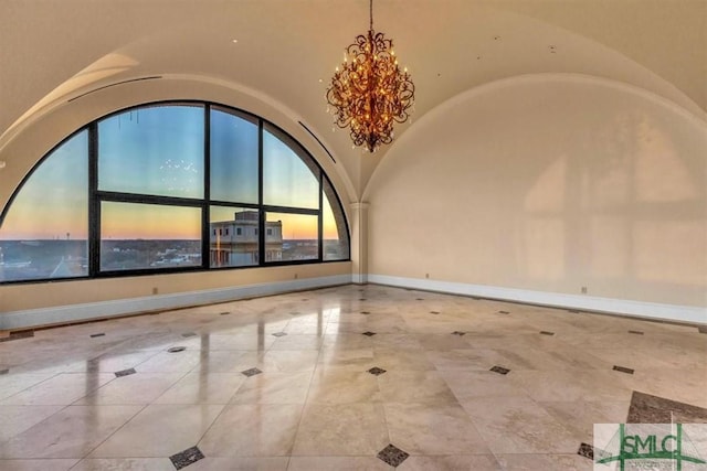 spare room with a notable chandelier, baseboards, and lofted ceiling