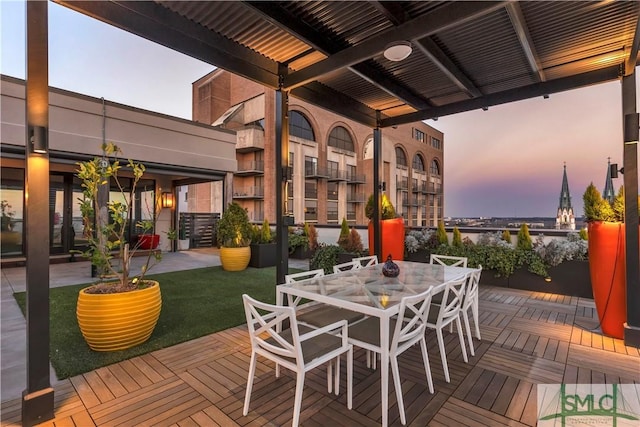 deck at dusk featuring outdoor dining area