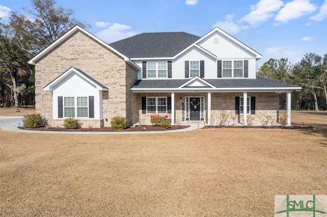 view of front of house with covered porch and a front lawn