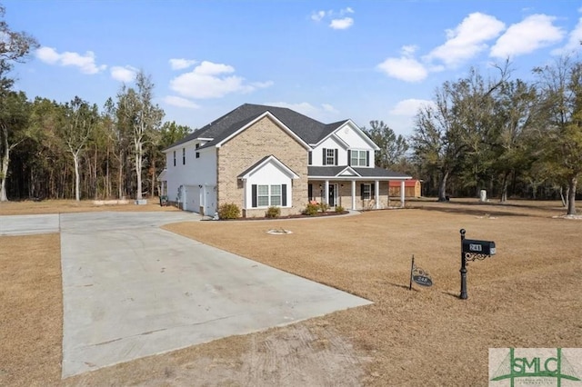 view of front facade featuring a garage, covered porch, and a front yard