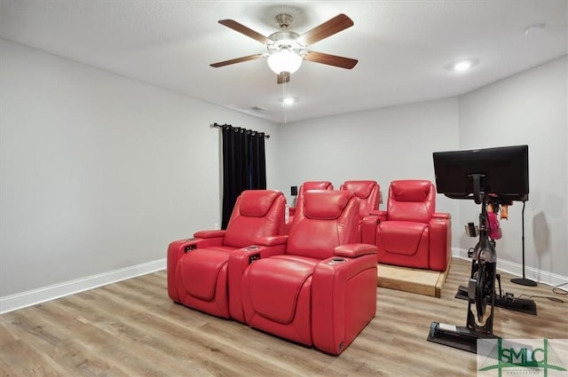 cinema room featuring hardwood / wood-style flooring and ceiling fan