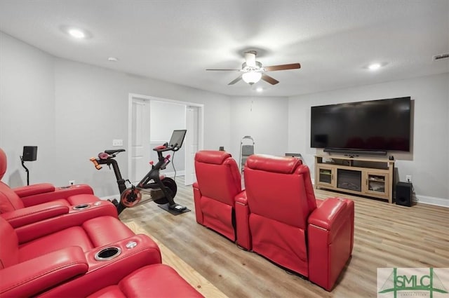 cinema room featuring ceiling fan and light hardwood / wood-style flooring