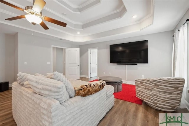 living room featuring crown molding, hardwood / wood-style floors, ceiling fan, and a tray ceiling