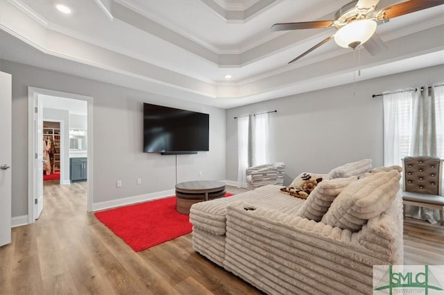 living room featuring crown molding, ceiling fan, a raised ceiling, and hardwood / wood-style floors