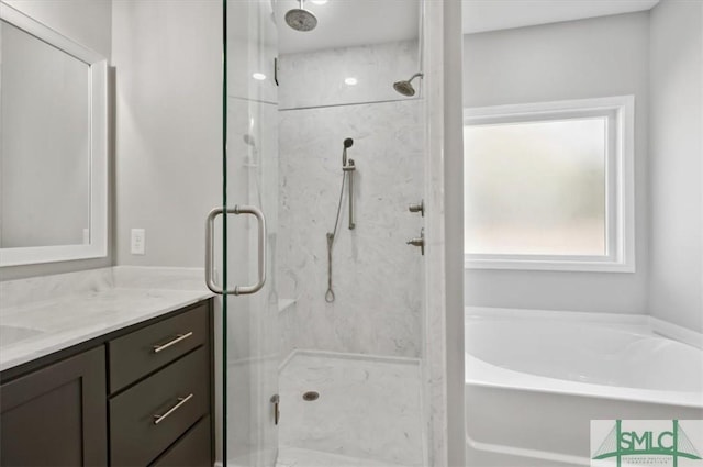 bathroom featuring vanity and independent shower and bath