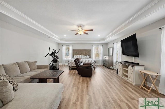 living room with crown molding, ceiling fan, a tray ceiling, and light hardwood / wood-style floors