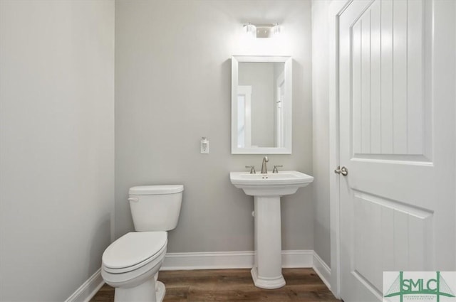 bathroom featuring wood-type flooring and toilet