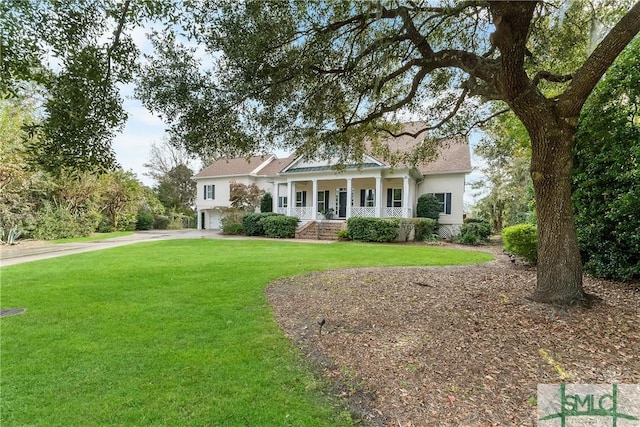 view of front of property featuring a porch, a garage, and a front yard