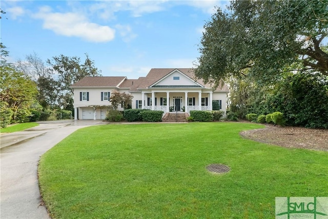 view of front of house with a garage, a front lawn, and covered porch